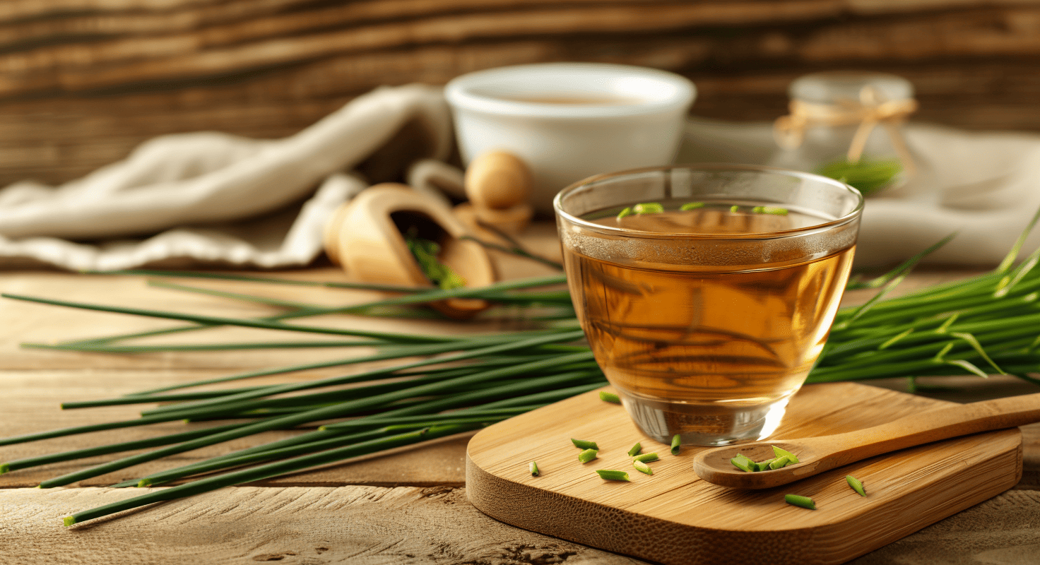 Taza de infusión de cola de caballo con tallos verdes frescos sobre una tabla de madera.