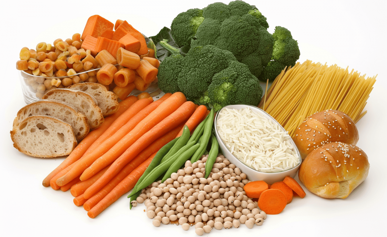 Variedad de alimentos ricos en fibra como zanahorias, brócoli, garbanzos, espaguetis integrales y pan de cereales.
