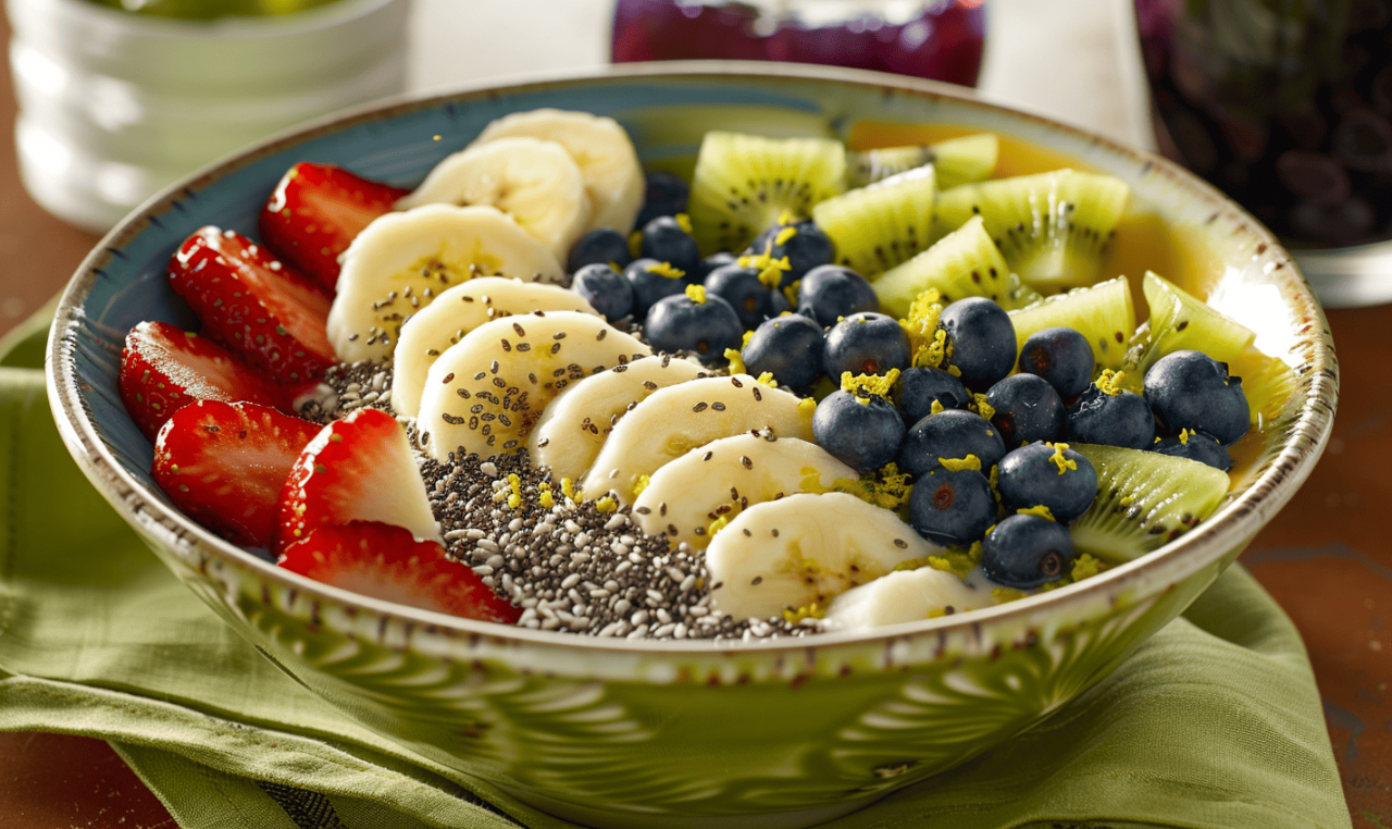 Acai bowl en tazón verde con fresas, plátano, kiwi, arándanos y semillas de chía sobre mantel verde.