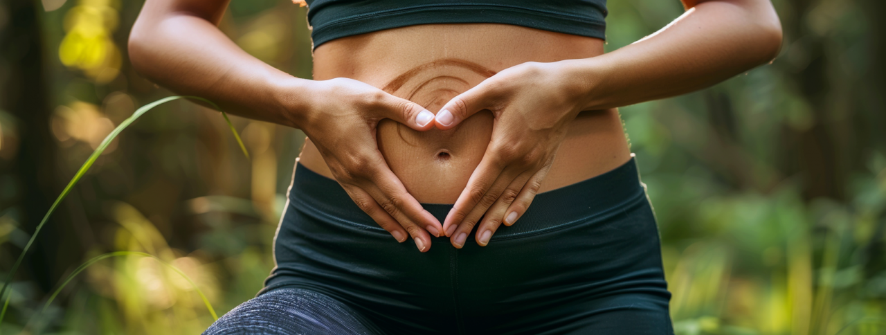 Manos formando un corazón sobre el abdomen para representar la salud digestiva y los distintos tipos de SIBO.